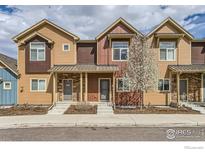 Beautiful townhome exterior featuring tan siding, stone accents, and a well-maintained front yard at 1240 Wren Ct # I, Longmont, CO 80501