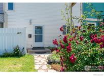 Charming home featuring a well-manicured yard and vibrant flowers near the entry at 1616 Longbow Ct, Lafayette, CO 80026