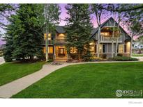 Charming two-story home featuring a manicured lawn and mature trees at 1775 Rockies Ct, Lafayette, CO 80026