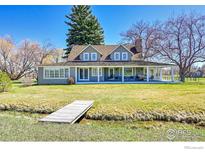 Charming gray home featuring a spacious wrap-around porch and a picturesque water feature at 2994 75Th St, Boulder, CO 80301