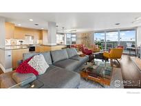 Bright living room showcasing a stylish sectional, modern decor, and a seamless transition to the kitchen and balcony at 4570 E Yale Ave # 1104, Denver, CO 80222