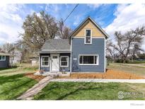 Charming blue two-story home featuring a gabled roof, white trim, and well-maintained front lawn at 1031 N 4Th St, Berthoud, CO 80513
