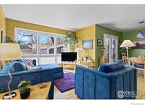 Inviting living room features bright natural light, hardwood floors, and comfortable blue contemporary-style furniture at 2276 Goss Cir, Boulder, CO 80302