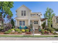 Charming two-story home featuring a beautifully landscaped front yard and inviting front porch with stone accents at 245 Spruce St, Louisville, CO 80027
