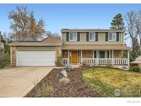 Charming two-story home featuring solar panels, a welcoming front porch, and a well-manicured lawn at 357 W Harper St, Louisville, CO 80027