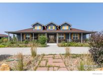 Charming blue home featuring a welcoming front porch with a swing and beautiful, colorful landscaping at 3967 Eastout Ave, Parker, CO 80138