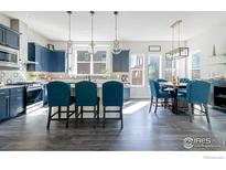 Modern kitchen features a large island with bar seating and stylish pendant lighting at 438 Meridian Ln, Superior, CO 80027