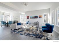 Open-concept living room with contemporary sofas, stylish decor, and ample natural light from large windows at 438 Meridian Ln, Superior, CO 80027
