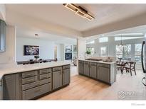 Modern kitchen with a light color scheme, quartz countertops, and seamless flow into the living areas at 5855 Rustic Knolls Dr, Boulder, CO 80301