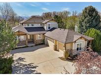 Stunning home with a three-car garage and beautiful stonework on a well-manicured lawn with mountain views at 7947 Ute Hwy, Longmont, CO 80503
