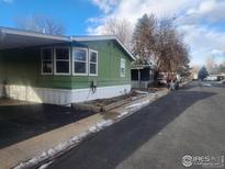 Charming green home with white trim, set amidst a serene residential neighborhood at 809 Flamingo Cv, Lafayette, CO 80026