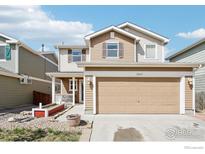 Two-story home featuring neutral toned siding, two car garage and small front porch at 10433 Forester Pl, Longmont, CO 80504
