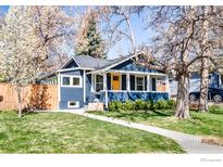 Charming blue craftsman home with landscaped front yard and inviting yellow door at 1109 Main St, Louisville, CO 80027