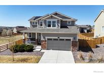 Charming two-story home with gray siding, stone accents, and a well-maintained front yard at 13485 Niagara St, Thornton, CO 80602