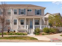 Charming townhome features a covered front porch, muted gray siding and blue shutters at 1679 Saratoga Dr, Lafayette, CO 80026
