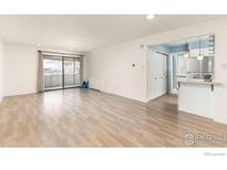 Bright living room with hardwood floors and sliding glass doors leading to a balcony at 2227 Canyon Blvd # 306A, Boulder, CO 80302