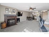 Inviting living area features carpet, fireplace, and ceiling fan, flowing into the kitchen for easy entertaining at 2660 E Otero Pl # 7, Centennial, CO 80122