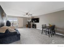 Spacious living room featuring a cozy fireplace, television and neutral tones with soft carpeting at 2660 E Otero Pl # 7, Centennial, CO 80122