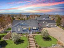 Stunning aerial view of a home featuring a well-manicured lawn and beautiful mountain views in the background at 3560 Cottonwood Cir, Frederick, CO 80504