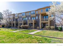 Inviting townhouse exteriors with well-kept lawns, charming balconies, and blossoming trees at 658 Casper Dr, Lafayette, CO 80026