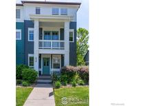 Inviting two-story townhouse with a porch and balcony, complemented by lush landscaping and a well-manicured lawn at 658 Casper Dr, Lafayette, CO 80026