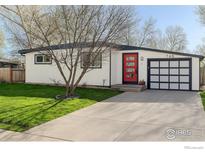 Charming single-story home featuring a red front door, modern garage door, and a well-manicured lawn at 740 32Nd St, Boulder, CO 80303