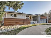 Inviting home featuring a modern design, a slatted fence, and professional landscaping at 7750 W 9Th Ave, Lakewood, CO 80214