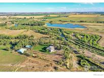 Aerial view of the property showing the home, buildings, river and pond at 10690 County Road 1, Longmont, CO 80504