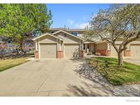 Inviting townhome featuring a two-car garage and well-maintained landscaping at 1202 Warrior Way, Lafayette, CO 80026