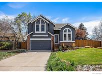 Charming two-story home with well-maintained lawn, inviting front porch, and attached two car garage at 13080 W 61St Cir, Arvada, CO 80004