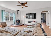 Cozy living room with hardwood floors, wood burning stove, and neutral colored walls at 15205 W 43Rd Ave, Golden, CO 80403