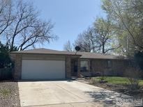 Charming single-story home with brick accents, attached garage, and well-maintained front yard at 1525 Peterson Pl, Longmont, CO 80501