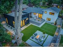 Beautiful backyard showcasing a modern patio area with a fire pit, lush lawn, and a deck perfect for entertaining at 1670 Linden Ave, Boulder, CO 80304