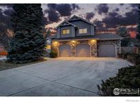 Stunning two-story home featuring a three-car garage with stone accents and a wide concrete driveway at 2215 Spotswood Pl, Boulder, CO 80304