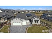 Beautiful gray home with a three-car garage and well-manicured lawn at 2774 Heron Lakes Pkwy, Berthoud, CO 80513