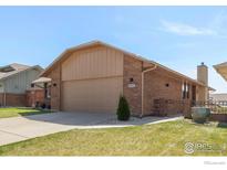 Charming brick home with a well-manicured lawn and attached two-car garage at 3401 Mountain View Ave, Longmont, CO 80503