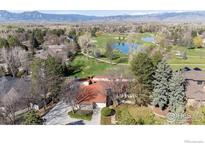Expansive aerial view of home with lush green golf course, serene pond, mature trees, and mountain views at 4749 Old Post Ct, Boulder, CO 80301