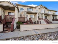 Charming townhouse with stucco facade, front porch, and manicured landscaping offers an inviting curb appeal at 546 Ridgeview Dr, Louisville, CO 80027
