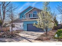 Charming two-story home with a well-maintained lawn, attached garage, and contemporary design at 803 Ithaca Dr, Boulder, CO 80305