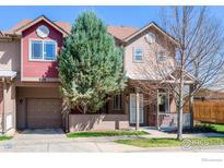 Charming townhome with a well-maintained lawn, attached garage, and covered front porch at 835 Kane Dr # 27, Longmont, CO 80501