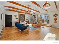 Bright living room with wooden beams, hardwood floors, and comfortable eclectic modern decor at 10978 W 82Nd Pl, Arvada, CO 80005