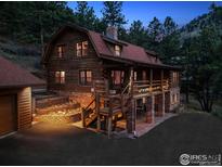 Stunning log home with a red roof and brick foundation nestled amongst tall pine trees, perfect for mountain living at 1280 N Cedar Brook Rd, Boulder, CO 80304