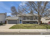 Charming two-story home with a blue door, attached garage, and mature trees in a well-maintained front yard at 145 S Buchanan Ave, Louisville, CO 80027
