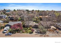 Ranch-style home with mature trees, a well-manicured lawn, and an attached two-car garage at 1746 Shavano St, Longmont, CO 80504