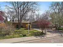 Charming single-story home with mature trees, a well-kept lawn, and a welcoming entrance at 1746 Shavano St, Longmont, CO 80504