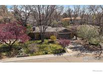 Charming single-story home with a well-manicured lawn and mature trees at 1746 Shavano St, Longmont, CO 80504