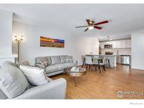 Bright living room featuring hardwood floors, modern decor, and an open concept design to the kitchen at 3300 Bridger Trl # 110, Boulder, CO 80301