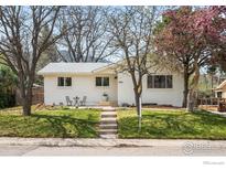 Charming single-story home featuring a well-manicured lawn and a cozy seating area in the front yard at 345 Colgate St, Boulder, CO 80305