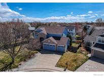 Inviting two-story home with a three-car garage and well-maintained landscaping on a sunny day at 355 Sprucewood Ct, Lafayette, CO 80026