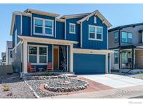 Charming two-story home featuring a modern blue exterior, complemented by a well-kept front yard with a rock garden at 364 Shawnee Ln, Superior, CO 80027
